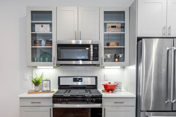 A kitchen with stainless steel appliances and white cabinets at anthem luxury rentals and apartments in huntsville, al